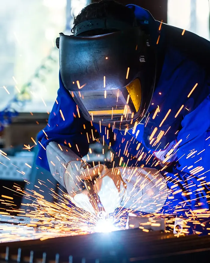 Welder joining steel sections in the fabrication shop