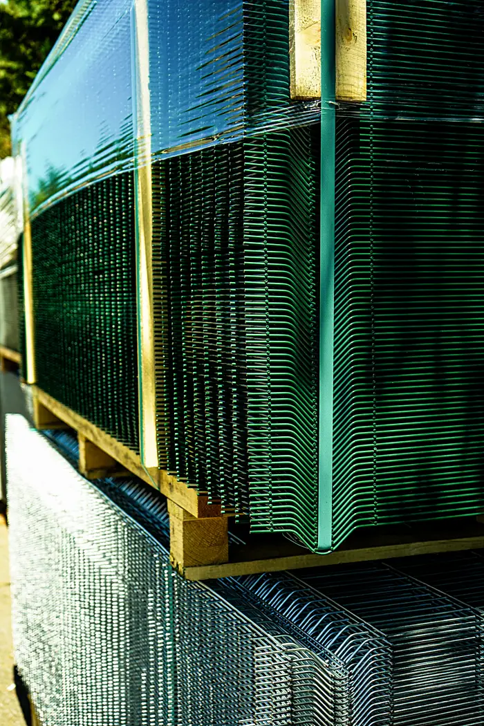 Green PVC-coated welded mesh panels strapped on a pallet